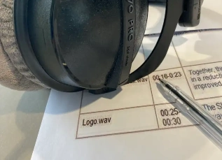 Professional recording studio headphones placed on a studio desk surrounded by audio equipment